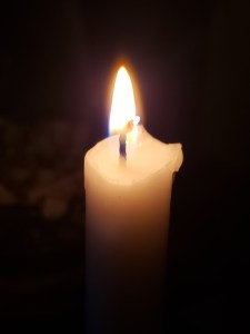 Candle burning bright while contrasting dark