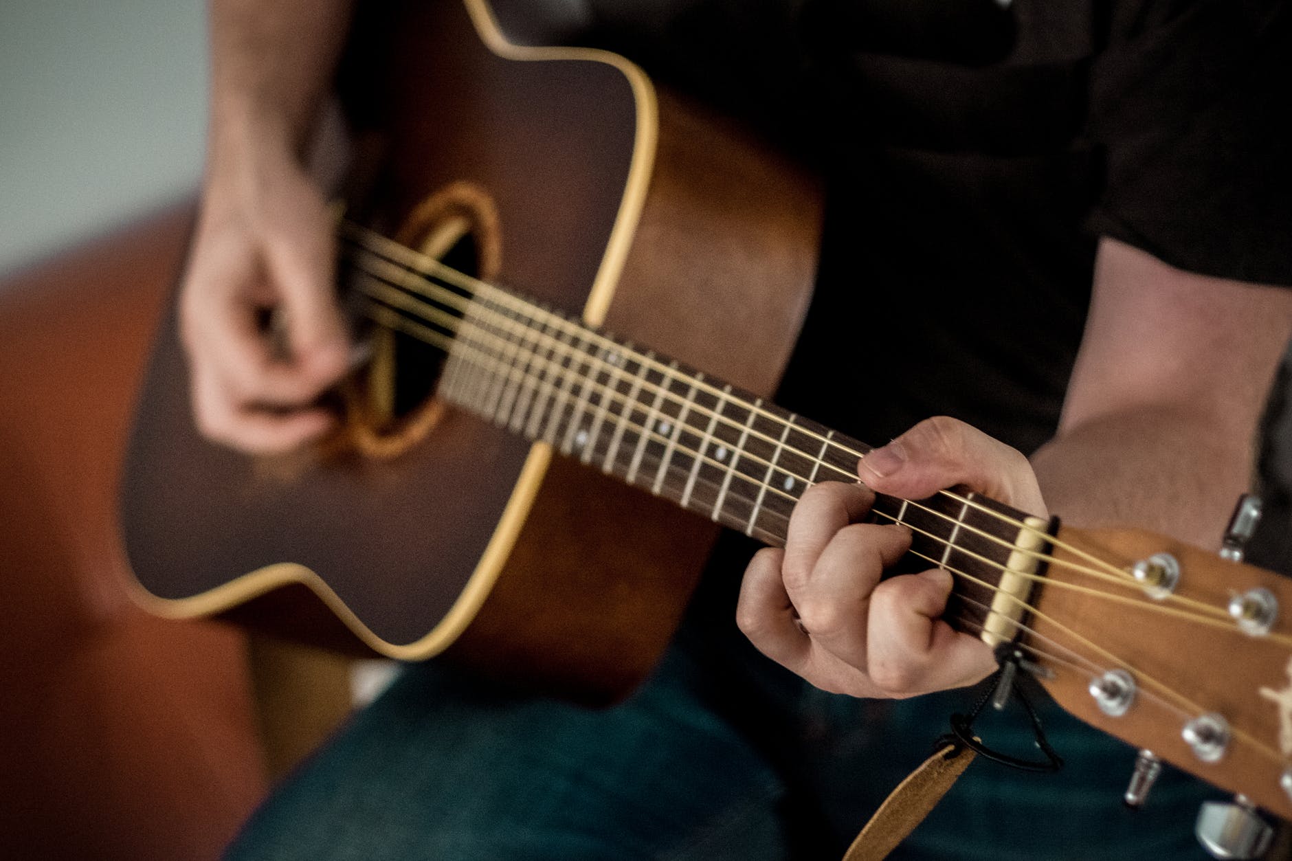 Guy playing an acoustic guitar in this stock image