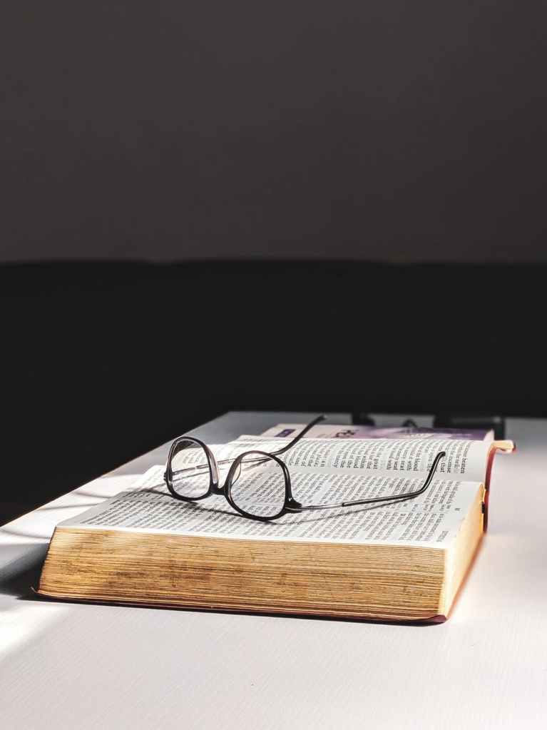 Stock Image of book with glasses on top of book