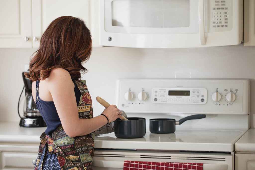 Stock photography of woman back in cooking a meal 