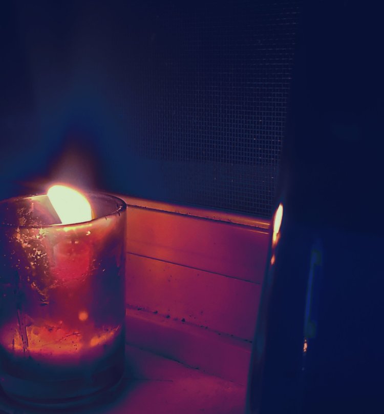 Winter night with candle on the window pain lighting the night