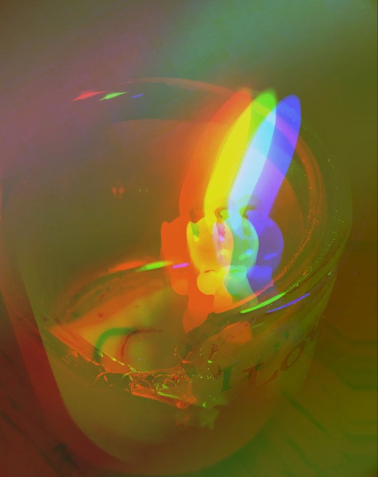 Candle lighting the darkness while edited and glitched exposing red yellow, blue, green.