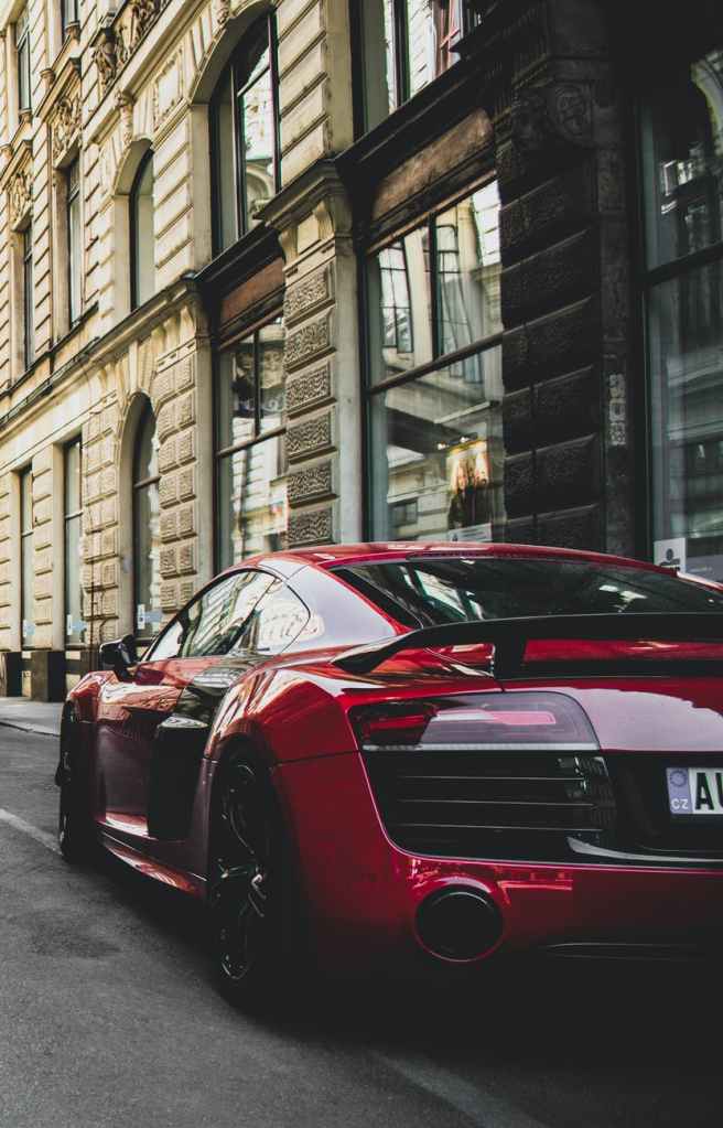 A red Ferrari parked outside a building in a city