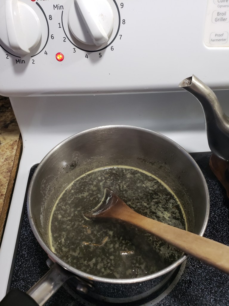 Stove top mixture of cannabis and butter being mixed while broiled slowly on minimum heat