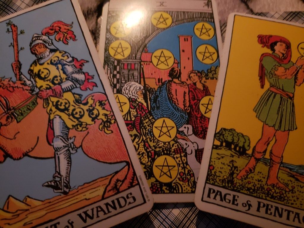 Tarot spread during March 2022 of the knight of wands, ten of pentacles and page of pentacles 